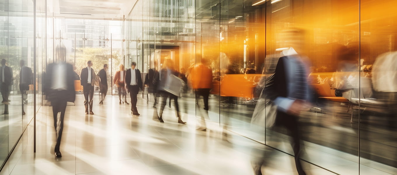 people walking through a glass office building